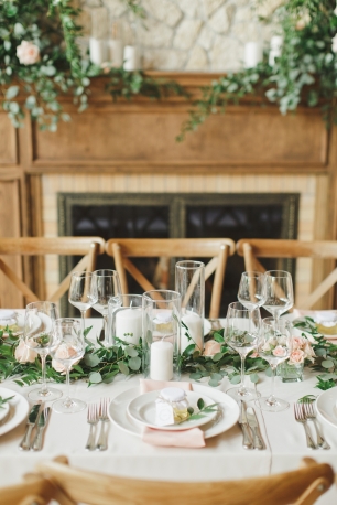 Утонченная сервировка гостевого стола, декорированного посередине гирляндой из зелени, цветов и свечей. Комплимент для каждого гостя - баночка мёда