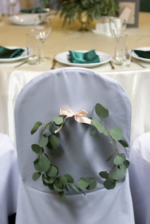 Стулья на свадебном торжестве, украшенный цветочным венком