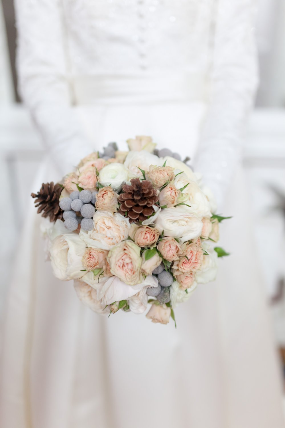 Букет невесты из ранункулусов, роз, брунии и шишек