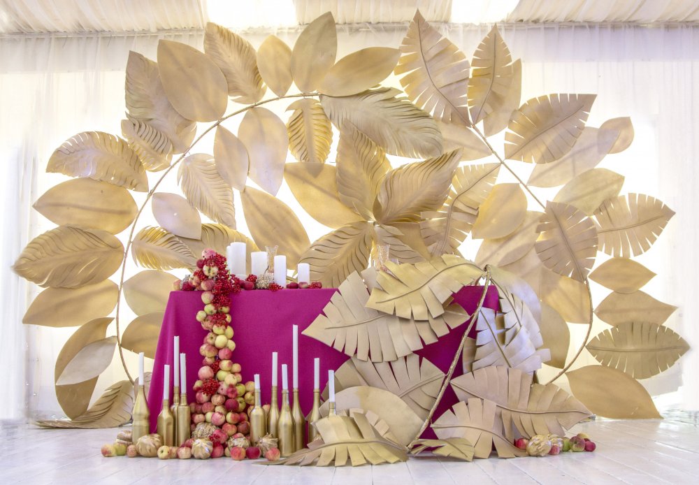 Декор стола молодоженов на свадьбе в осеннем стиле. Водопад из яблок, десятки свечей и фон из золотых листьев
