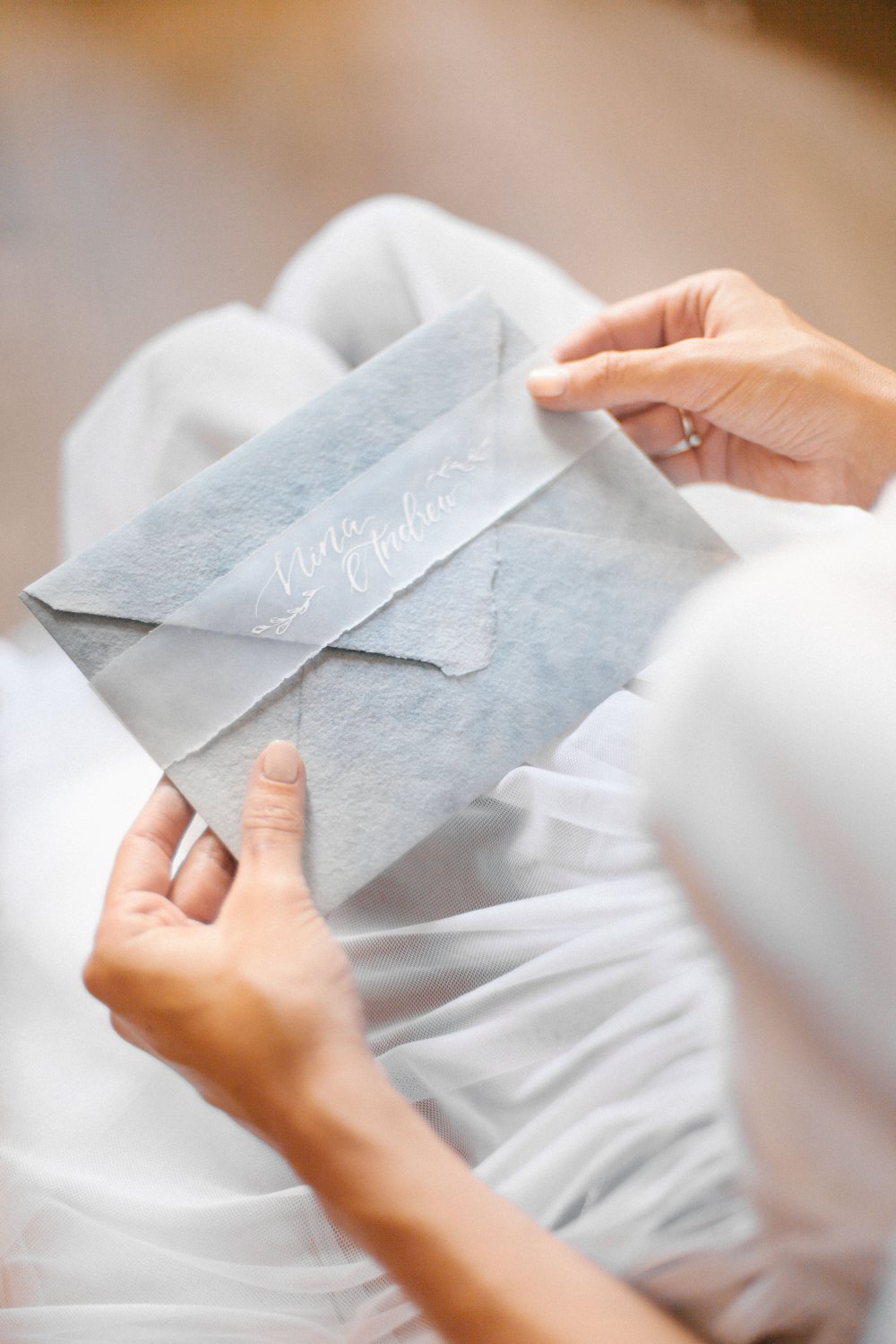 Конверт из бумаги ручного литья для свадебных приглашений. Свадьба в Черногории. Акцент в виде ленты из кальки с именами пары, написанными каллиграфией.