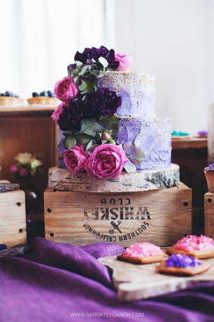 Сиреневый свадебный торт, украшенный цветами