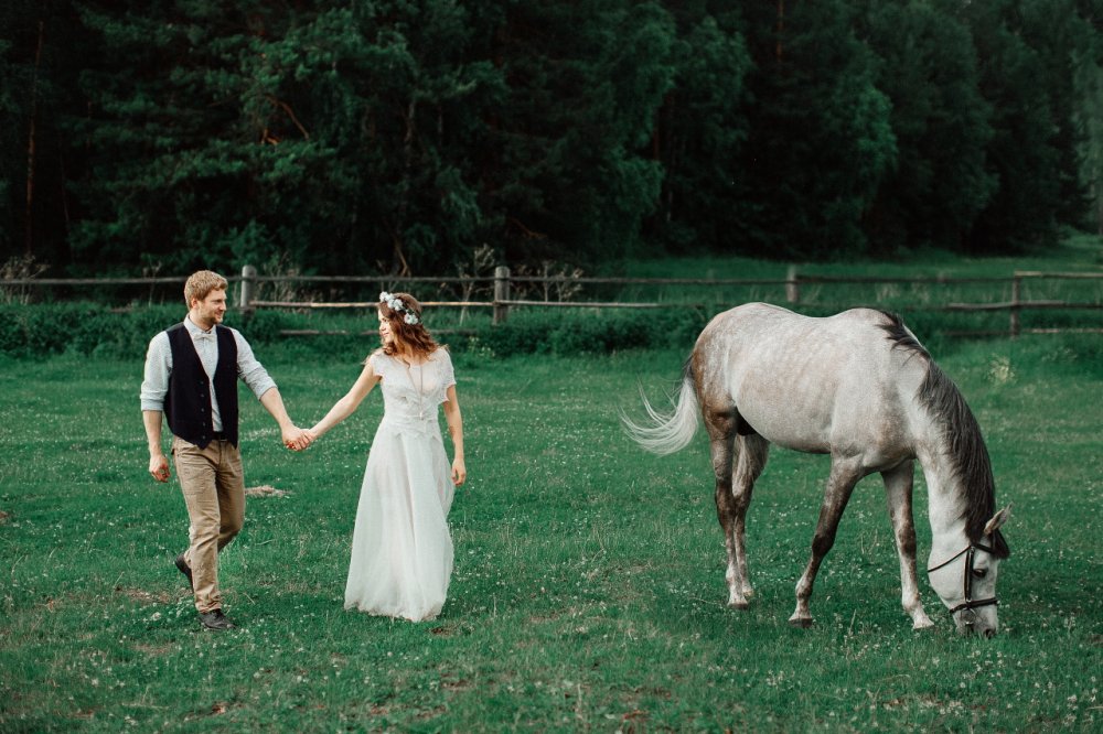 Фотосессия на ранчо. Жених с невестой рядом с лошадью