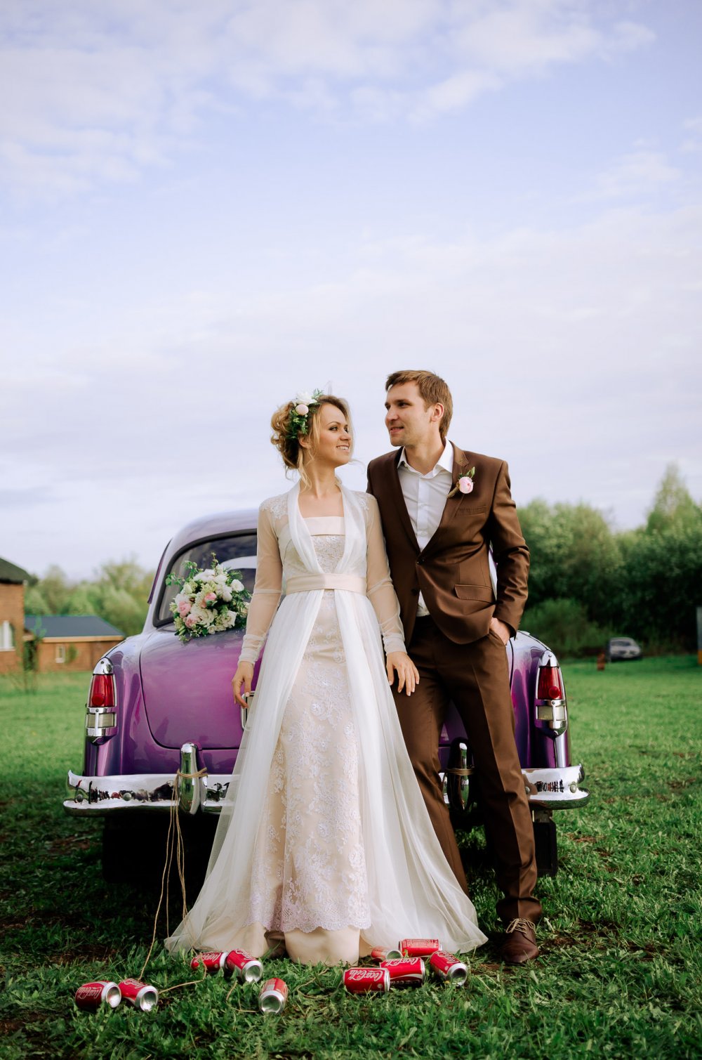 Жених и невеста на фоне свадебного автомобиля