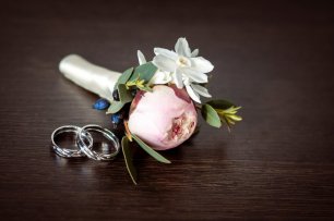 Бутоньерка для жениха выполнена из нежного еще нераскрывшегося бутона пиона розового цвета. Кольца абсолютно одинаковые из белого золота с бриллиантами.
