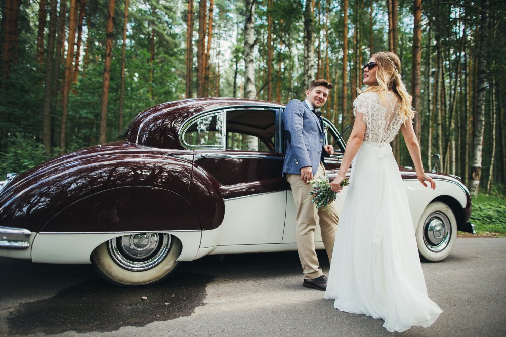 Жених и невеста на фоне красивого автомобиля