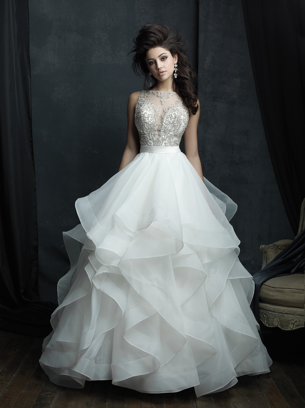 Пышное свадебное платье американского бренда Allure Bridals.

Эффектное свадебное платье с летящей многослойной юбкой с волнами. Лиф украшен бисером, кристаллами и серебряным плетением.