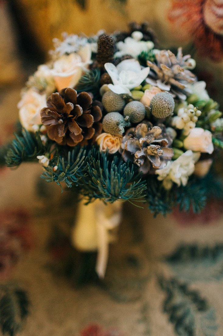 Букет невесты с еловыми ветками, шишками и цветами