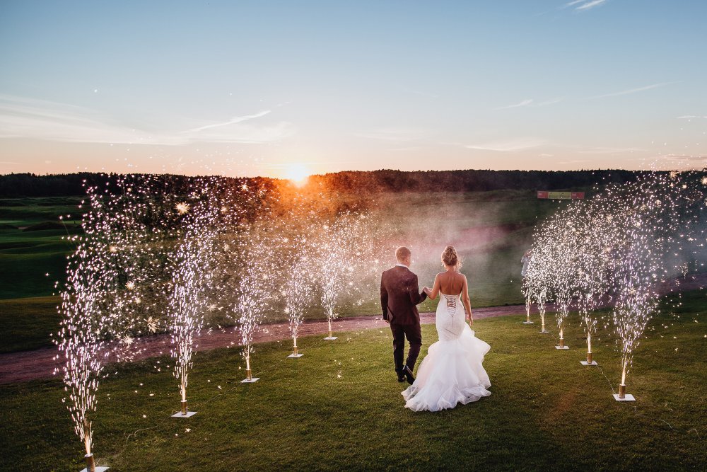 В завершении великолепного свадебного дня - головокружительный проход через дорожку из фонтанов в лучах закатного солнца. 