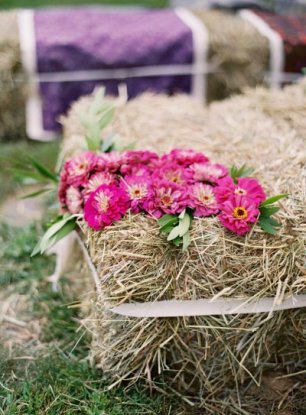 Для рустикальной свадьбы вместо стульев можно использовать стоги сена, декорированные цветами  