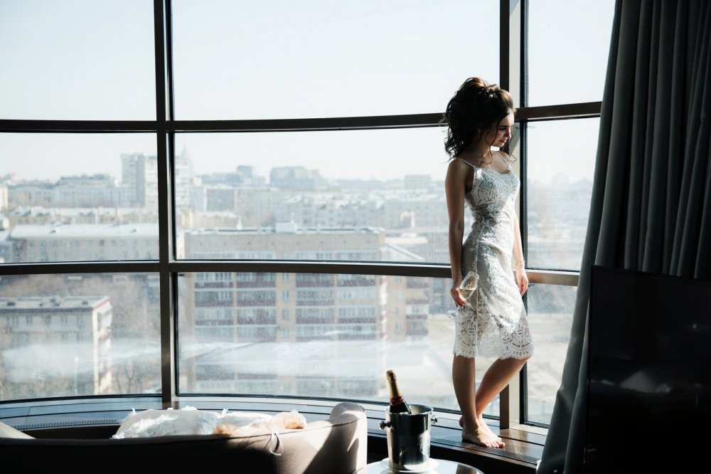 Девушка в одних трусиках стоит у панорамного окна фото