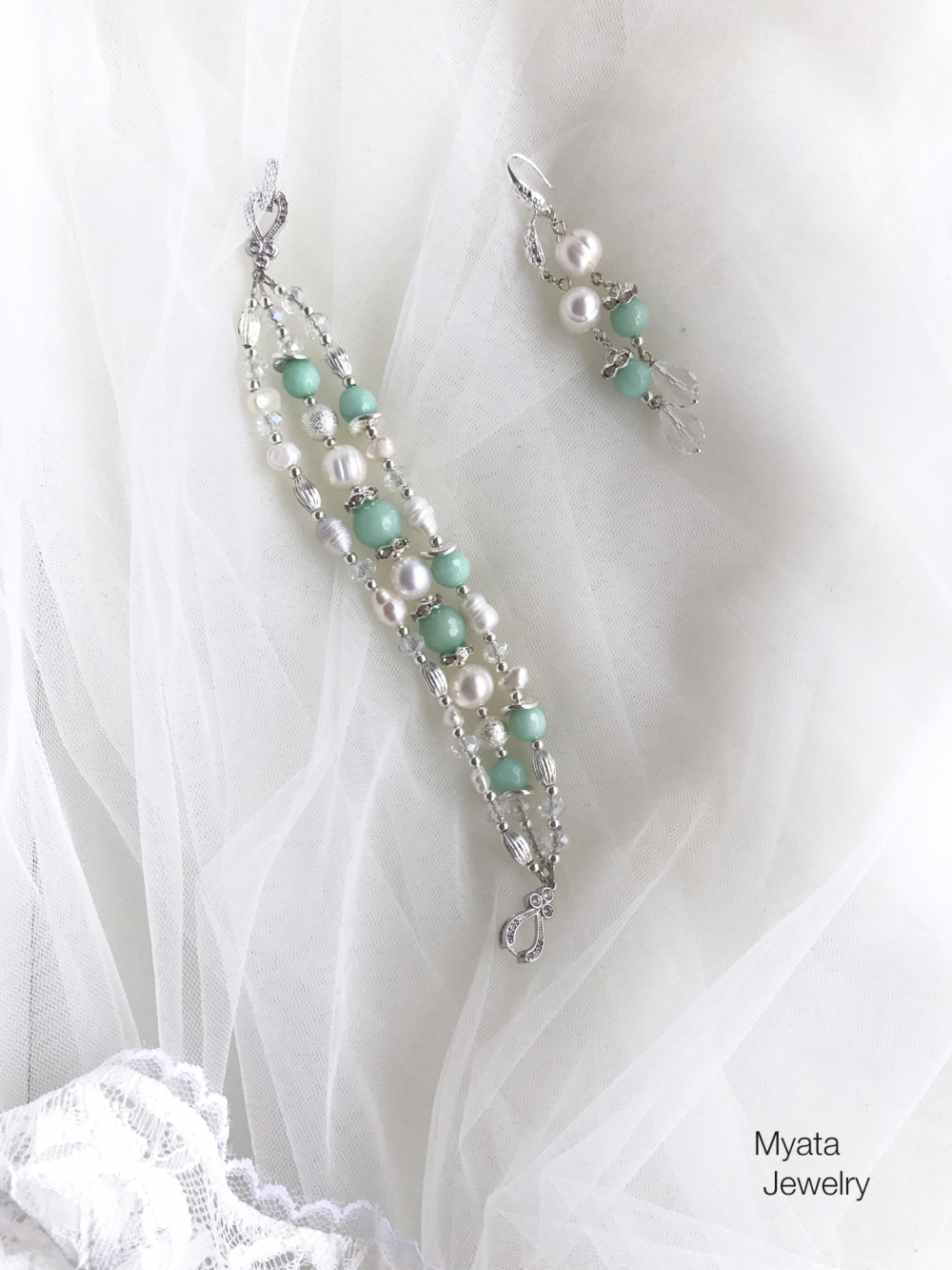 Нежный свадебный комплект из серег и браслета, с натуральным жемчугом и камнями потрясающего цвета tiffany.
Длина серег 6 см., цепочки 18 см. 
Цена комплекта по запросу.