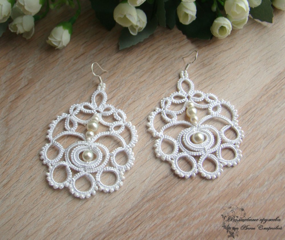 Свадебные серьги "Катерина" выполнены в старинной технике узелкового кружева - фриволите. 
Украшены стеклянным жемчугом и чешским бисером.
Серьги очень легкие. Кружево отлично держит форму, за счет использования специализированной нити в производстве.
Цвет белый.
Возможно исполнение в другом цвете.
