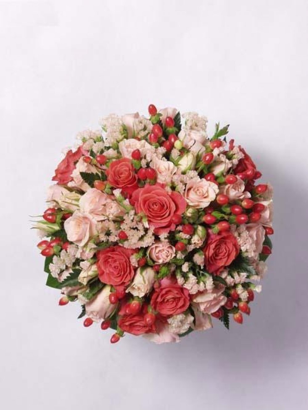 Букет из роз, ярко-красного гиперикума и нежной эустомы.