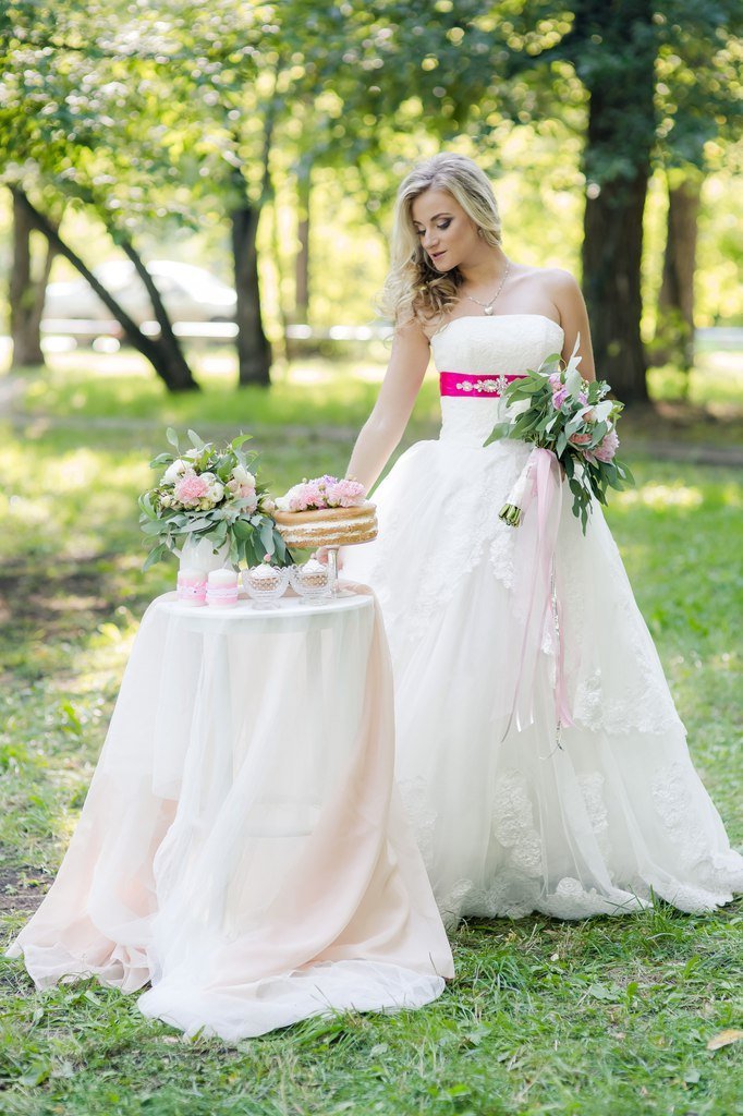 Невеста рядом с оформленным столиком с угощениями