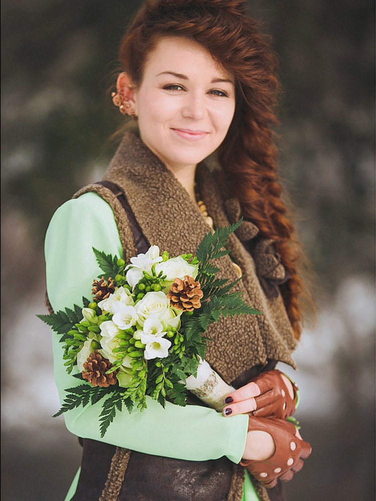 Нежный и утонченный образ для зимней свадьбы в эко-стиле. Мягкие оттенки в наряде невесты подчеркнуты зеленью папортника и белоснежностью фрезий, а сосновые шишки в составе букета и березовая кора в декоре прекрасно гармонируют с атмосферой зимнего леса.