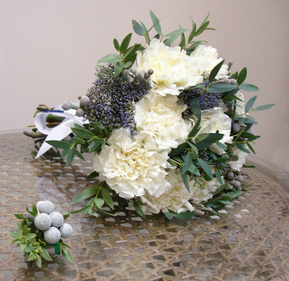 Небольшой строгий букет с гвоздиками смягчен слегка вольной формой.