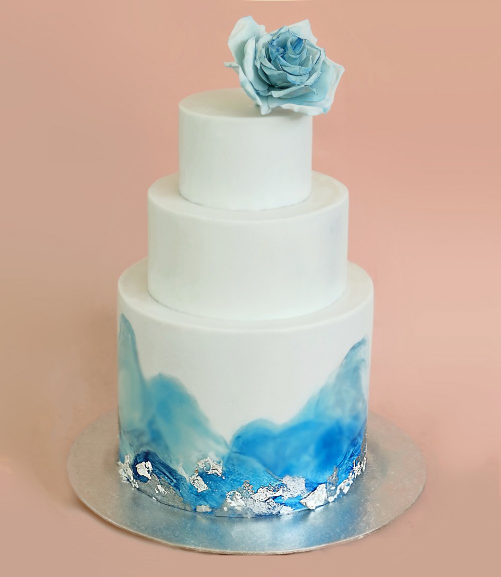 Белый торт с мини ярусами, голубой акварельной росписью, пищевым серебром и льдистой сахарной розой