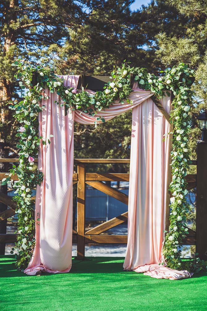 Арка с гирляндой из зелени и цветов