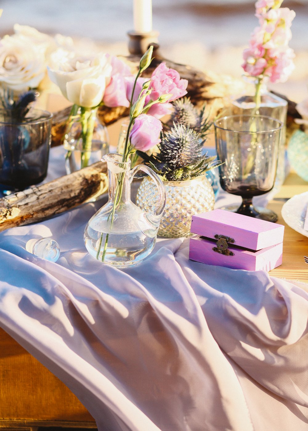 Ужин на заливе. Сочетание натуральных и декоративных элементов: легкие струящиеся ткани и текстура дерева, маленькие прозрачные и керамические вазочки и самая настоящая коряга, потертое серебро и нежные цветы.