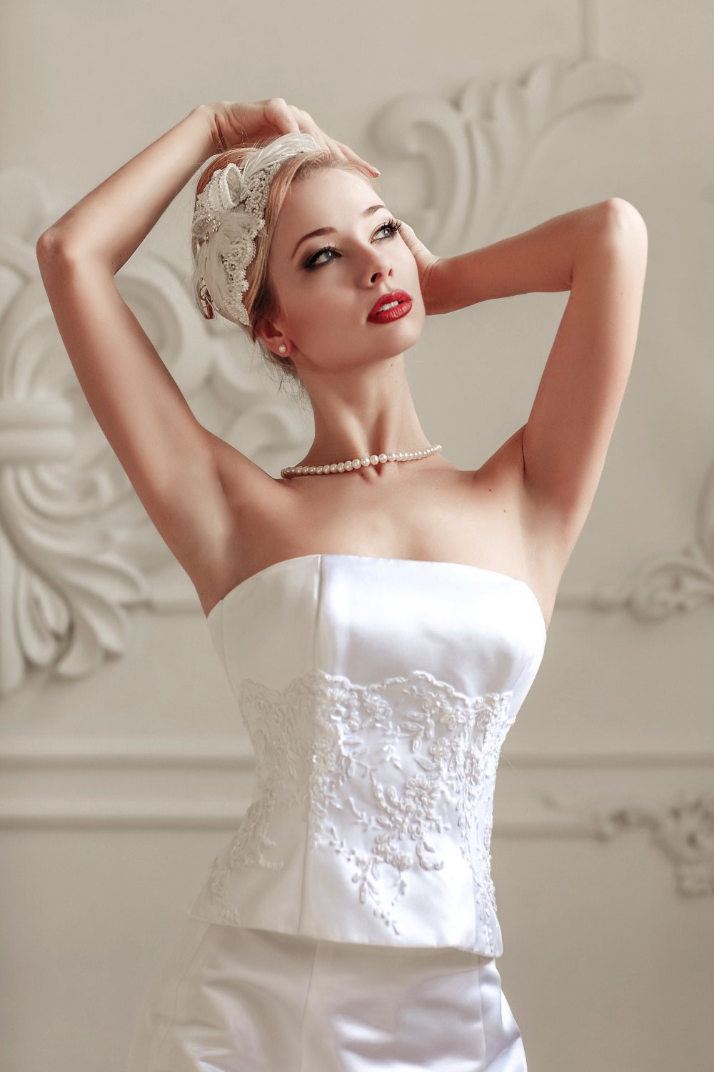 Длинные волосы собраны в высокую элегантную прическу, макияж с яркими красными губами, но в тоже время и глазки не оставлены без внимания засчет стрелки и ресничках в пучках.