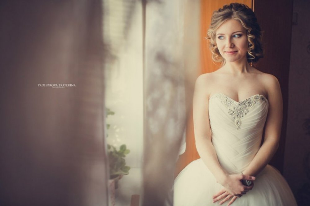 Романтичные локоны, убранные в ажурный пучок, неяркий макияж с акцентом на глаза, придали образу нежности