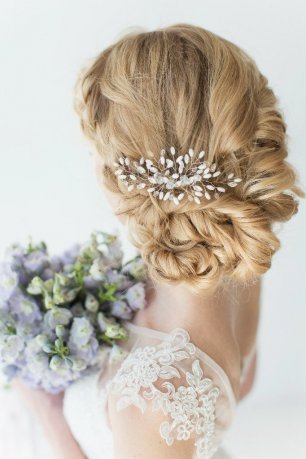 Изысканная свадебная прическа, украшенная серебристым гребешком