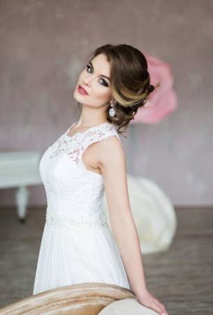 Шикарный свадебный образ, собранная прическа в низкий пучок с использованием накладных прядей.