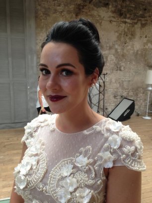 Аккуратный высокий пучок и макияж с акцентом на сиящую кожу. Густые ресницы и чувственные губы