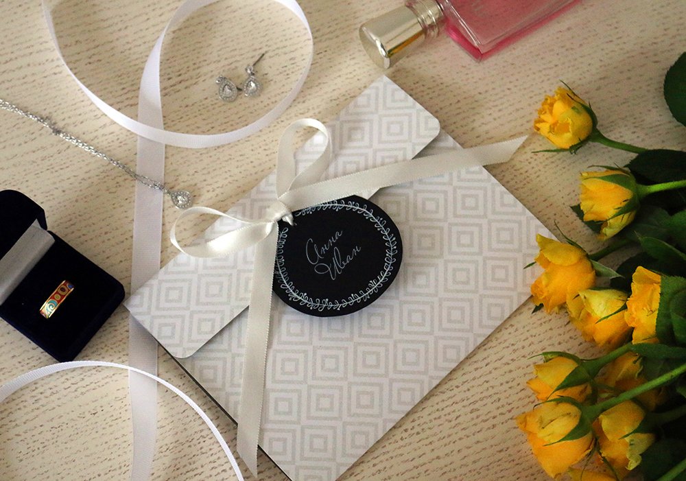 Сдержанное и лаконичное приглашение снаружи, яркое и озорное внутри для яркого тандема Ульяны и Дмитрия. 
Дизайнерская бумага, хлопковая бумага, атласная лента, тушь, цифровая печать.