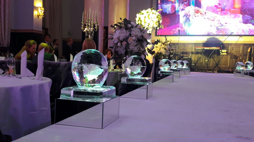 Ледяные шары в зеркальных поддонах с розой внутри для украшения подиума.