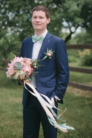 Жених в синем костюме и галстуке-бабочке мятного оттенка