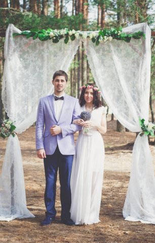 Жених и невеста на фоне свадебной арки