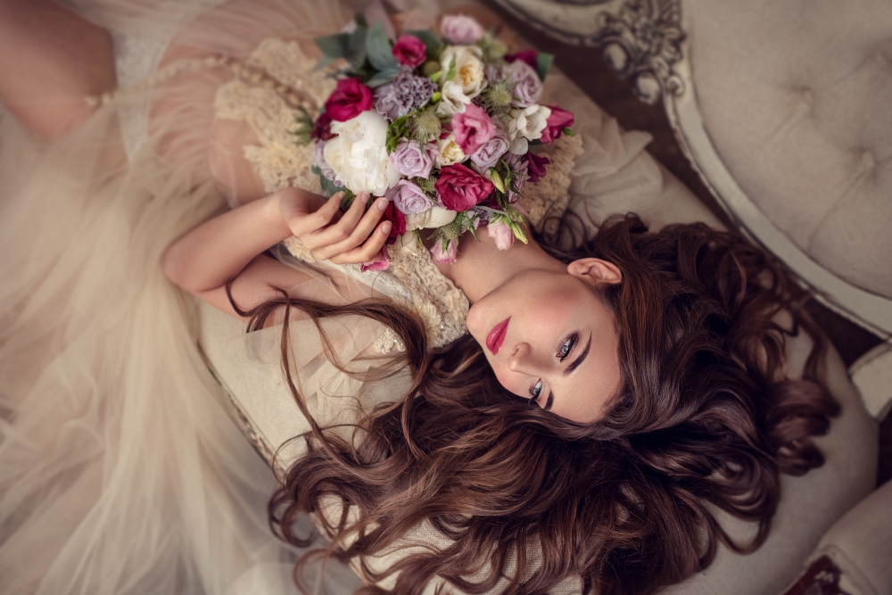 Портрет невесты лежа в будуарном платье с букетом. Утро невесты