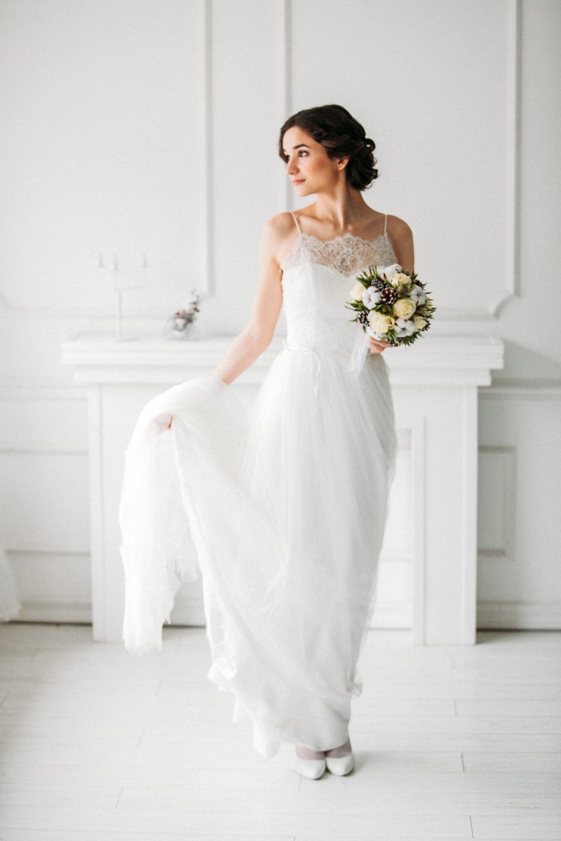 Невеста в нежном кружевном платье с букетом из хлопка и цветов