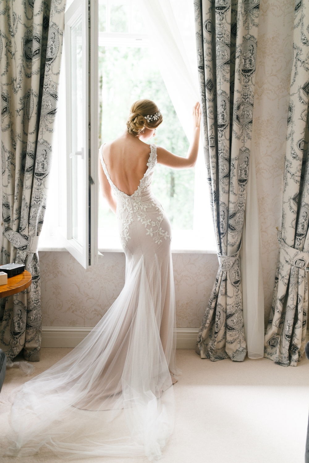 невеста стоит у окна спиной к зрителю