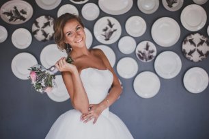 Невеста на фоне стены с тарелками