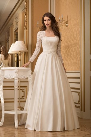 Модель Диас. Платье А-силуэта из шелкового микадо, поверх декольтированного платья с прямым срезом корсета одевается жакет из кордового кружева. Юбка в бантовую складку сзади переходит в шлейф средней длины, в боковых швах спрятаны кармашки. Волшебная мод