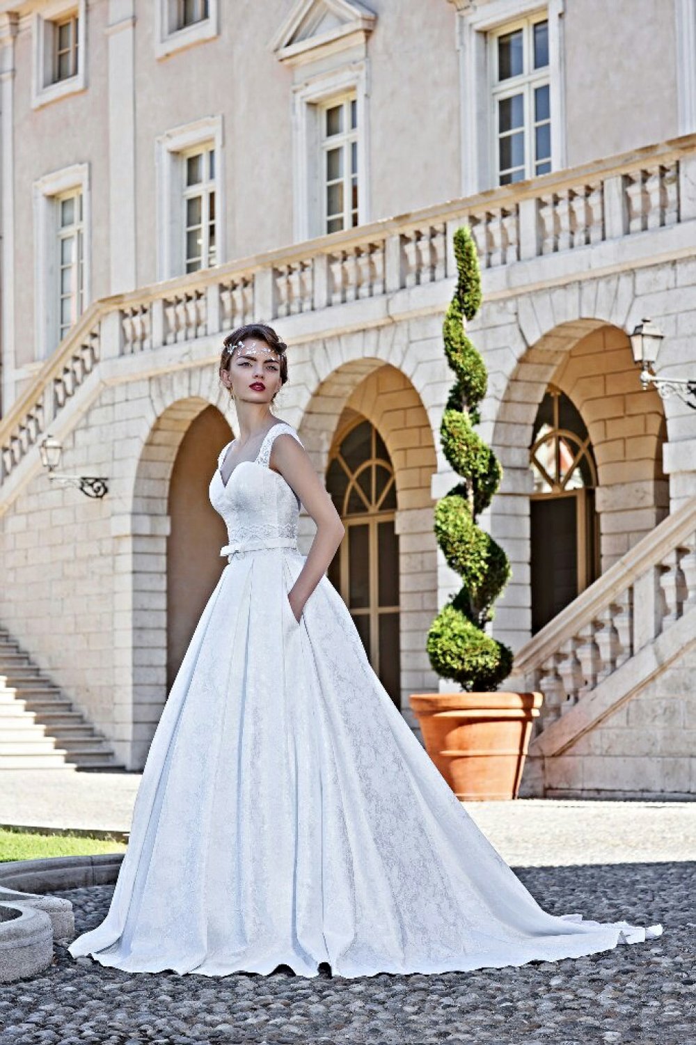 Свадебное платье "Лиона", цвет белый, размер 42. А-силуэт со шлейфом. На конце шлейфа вставка из кружева. Кружевные плечики и спинка на пуговицах. Карманы на юбке. Рисунок на ткани - выбитые цветы.