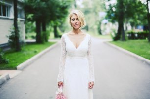 Невеста в кружевном свадебном платье с длинным рукавом