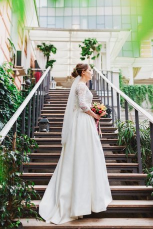 Невеста в кружевном платье и юбкой со шлейфом