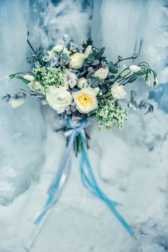Букет невесты на фоне голубого льда