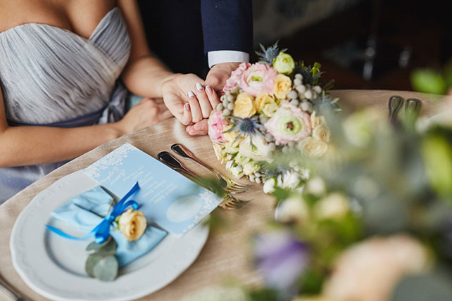 Элегантная свадьба в пыльно-голубом цвете, букет невесты на столе