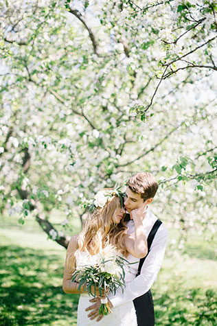 Свадебная фотосессия в яблоневом саду, жених и невеста обнимаются
