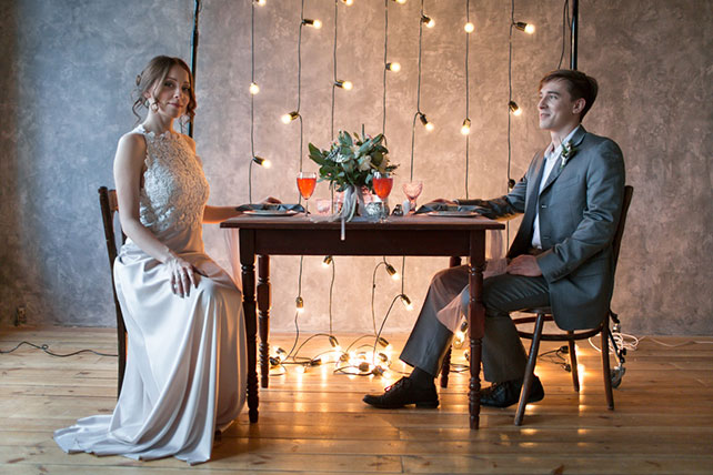 Весенняя свадебная фотосессия в студии, жених и невеста за столом