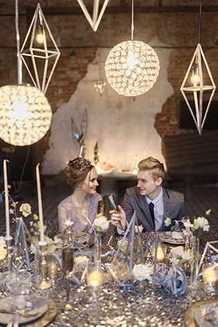 Ледяная геометрия: свадебная фотосессия в студии, серебристая скатерть, жених и невеста за столом, фонари