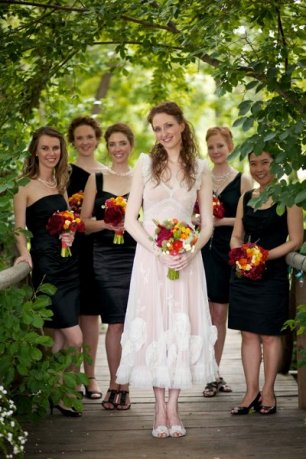 Подружки невесты в черных платьях и оранжевыми букетами 