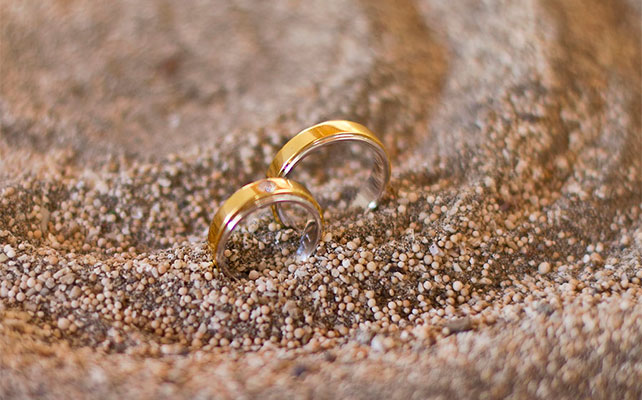 Кольца из желтого металла в песке