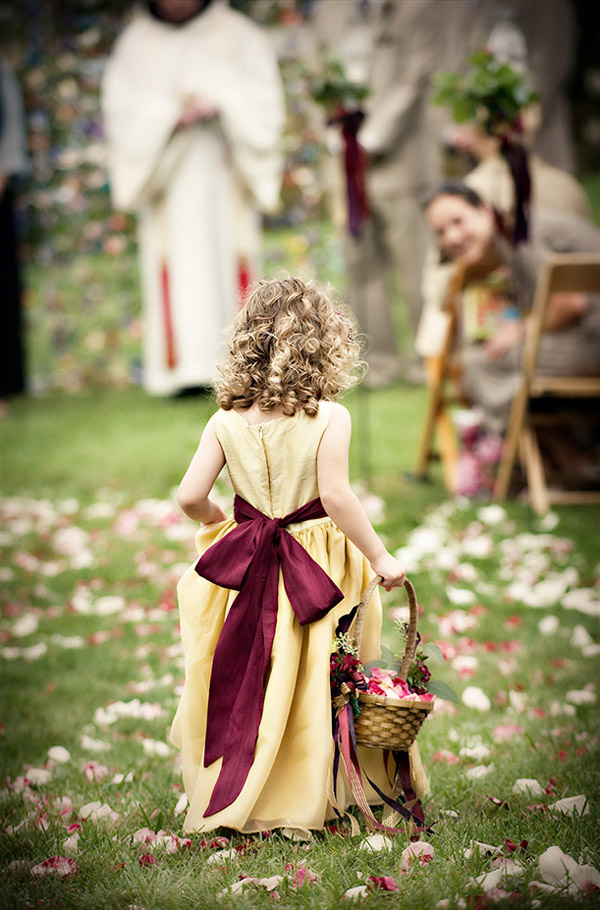 Цветочная девочка с корзиной лепестков на свадьбе