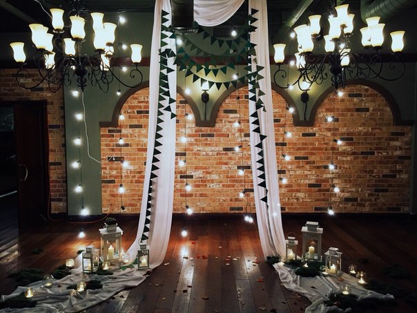 Прекрасное оформление свадебной фотозоны тканью, гирляндами и свечами